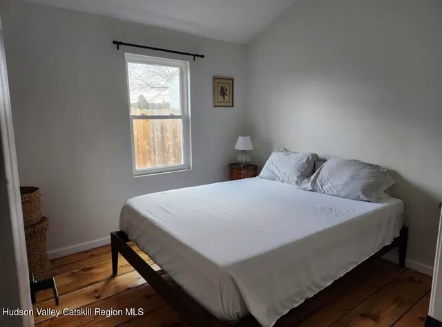 a bed sitting in a bedroom next to a window