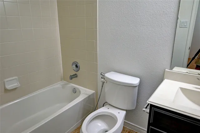 a white toilet sitting next to a bathtub