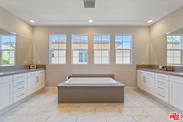 a bathroom with a tub sink mirror and shower