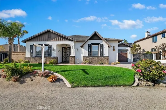 a view of a house with a yard and potted plants