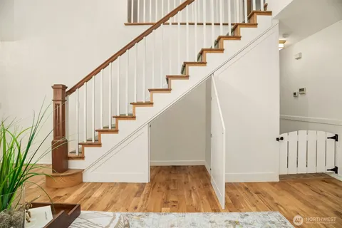a view of staircase with wooden floor and white walls