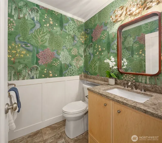 a bathroom with a granite countertop sink a toilet and mirror