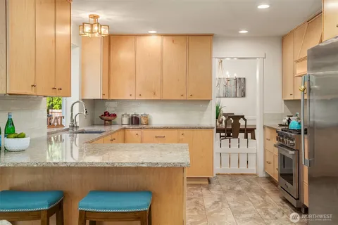a kitchen with stainless steel appliances granite countertop sink stove top oven and cabinets