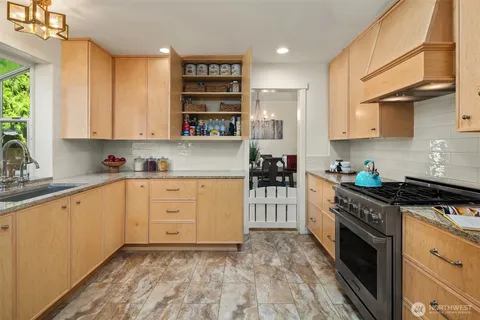 a kitchen with stainless steel appliances granite countertop a stove a sink and a refrigerator