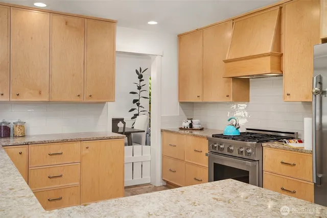 a kitchen with granite countertop a sink cabinets stainless steel appliances and a window