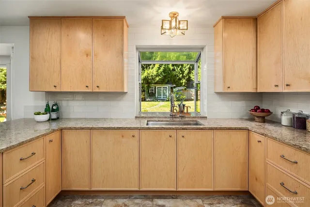 a kitchen with granite countertop white cabinets and a window