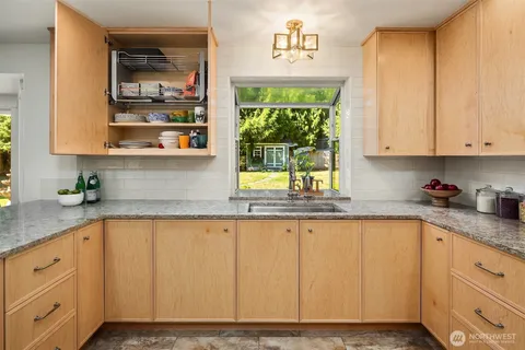 a kitchen with granite countertop white cabinets and window