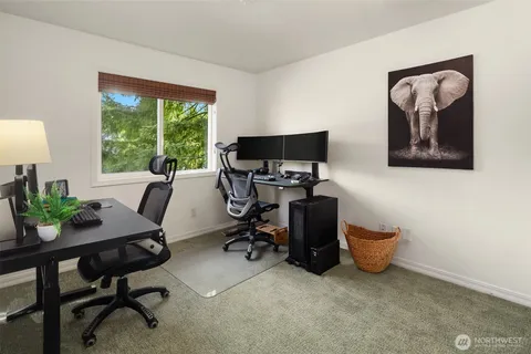a view of a workspace with furniture and a window