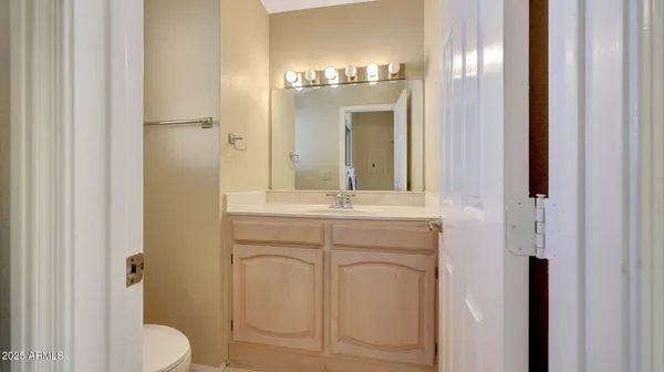 a bathroom with a granite countertop sink a toilet and a mirror