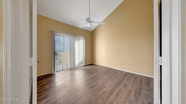 a view of a livingroom with wooden floor and a ceiling fan