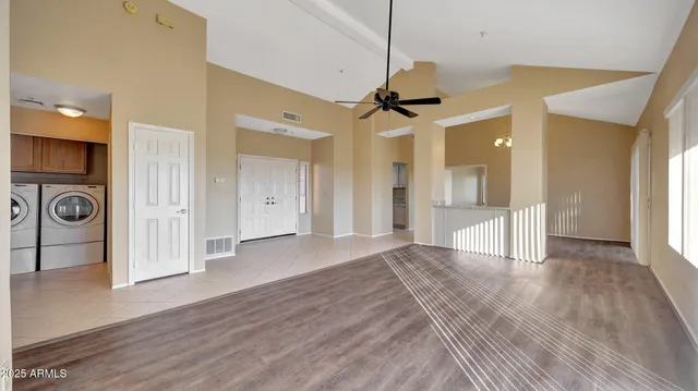 a view of a big room with wooden floor and windows