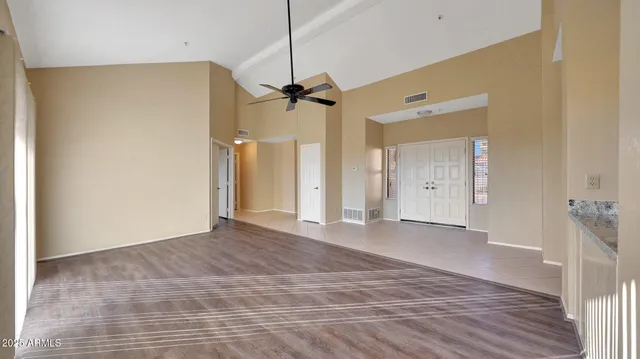 a view of a big room with wooden floor and windows