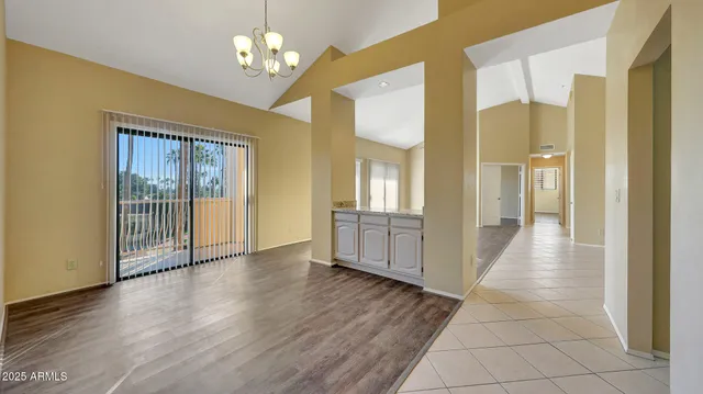 a view of a hallway with wooden floor and a chandelier