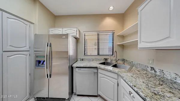 a kitchen with stainless steel appliances granite countertop a refrigerator and a sink