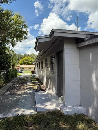 a small barn in front of a house with a yard