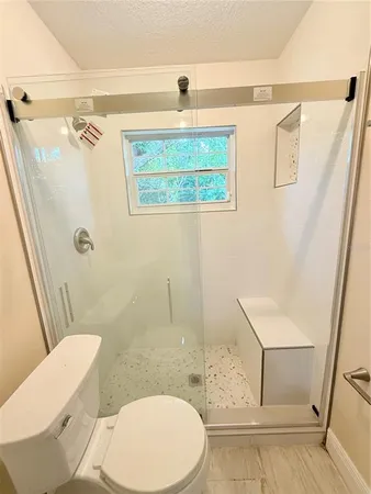 a white toilet sitting next to a bathroom sink and a shower