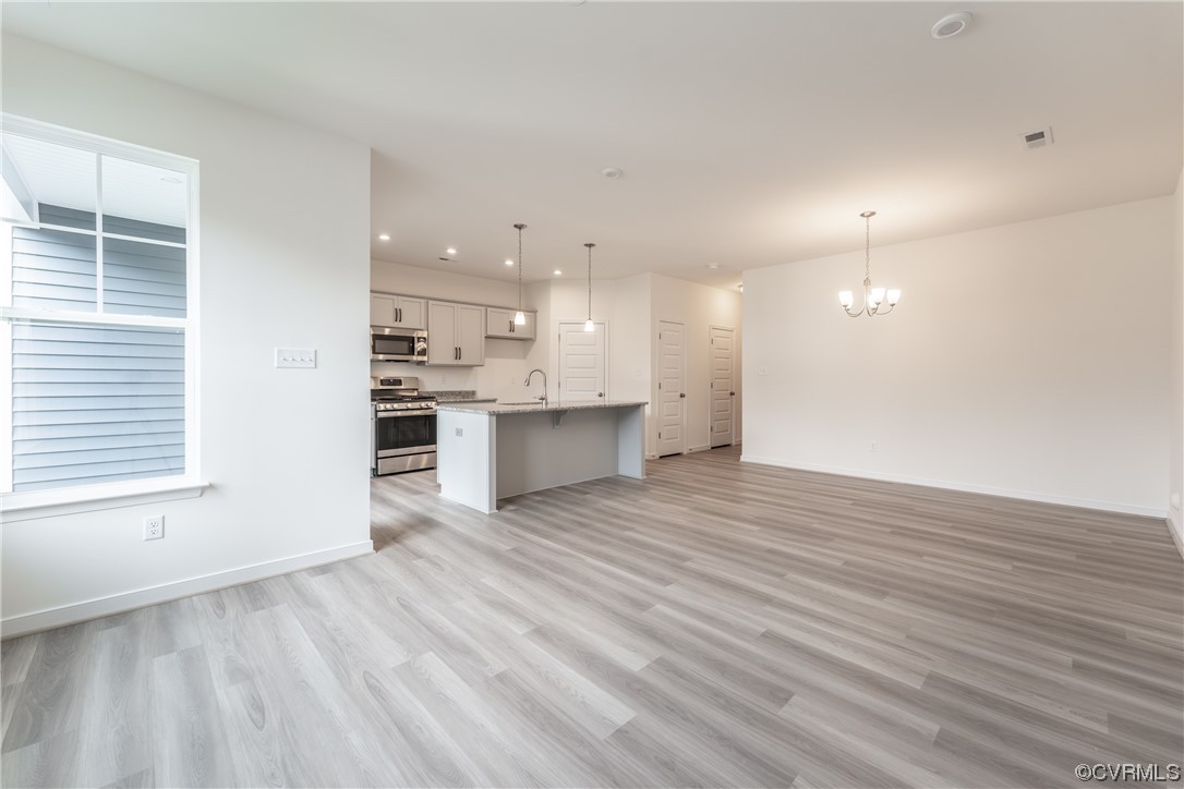 18609 Palisades Ridge Moseley, VA 23120 - Photo 11 of 50 a view of a kitchen with kitchen island a sink wooden floor and a refrigerator