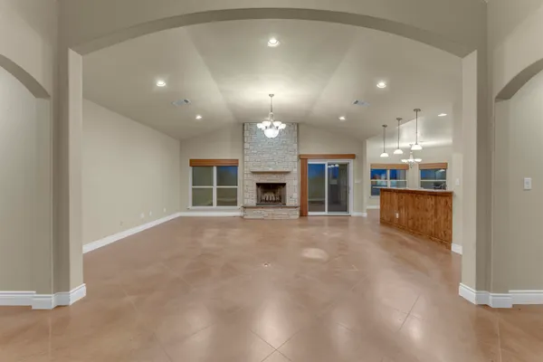 an empty room with kitchen and fireplace cabinets