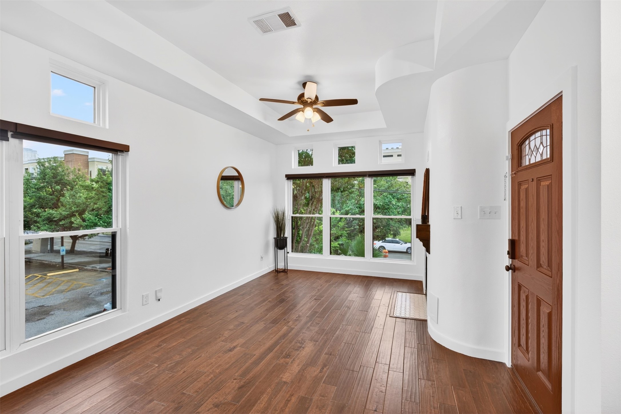 2716 Bagby Street Houston, TX 77006 - Photo 5 of 29 a view of a livingroom with wooden floor a ceiling fan and windows