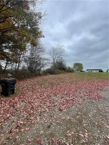 a view of a yard with wooden fence