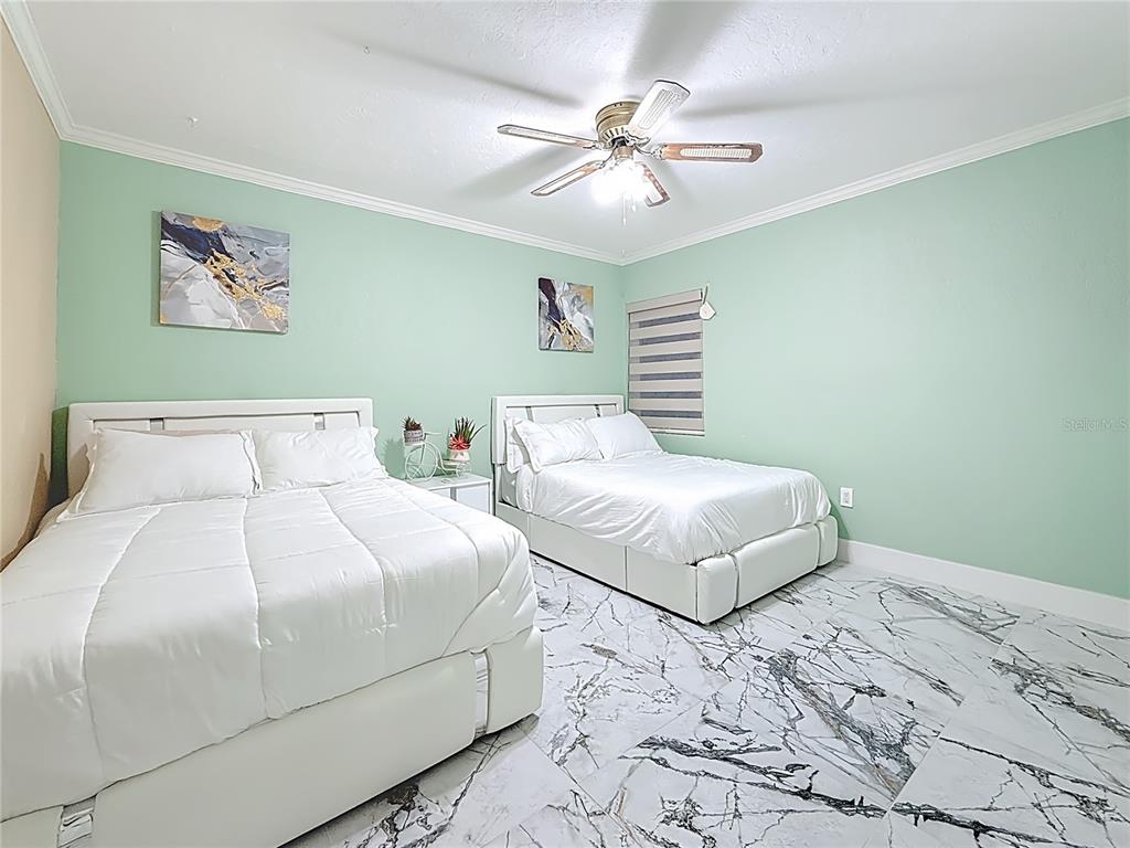 14186 West Parsley Drive Madeira Beach, FL 33708 - Photo 19 of 57 a bedroom with two beds and painting on the wall