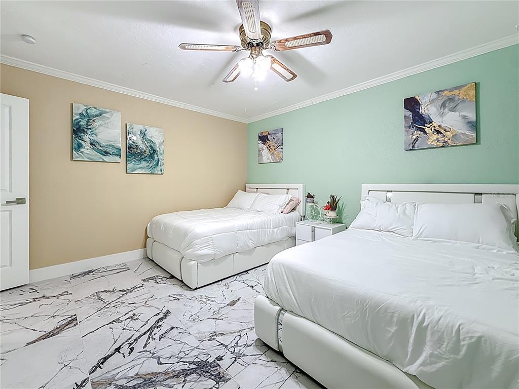 14186 West Parsley Drive Madeira Beach, FL 33708 - Photo 20 of 57 a bedroom with two beds and a painting on the wall