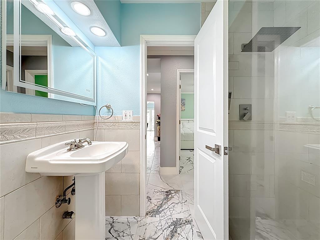 14186 West Parsley Drive Madeira Beach, FL 33708 - Photo 24 of 57 a bathroom with a sink a mirror and a shower