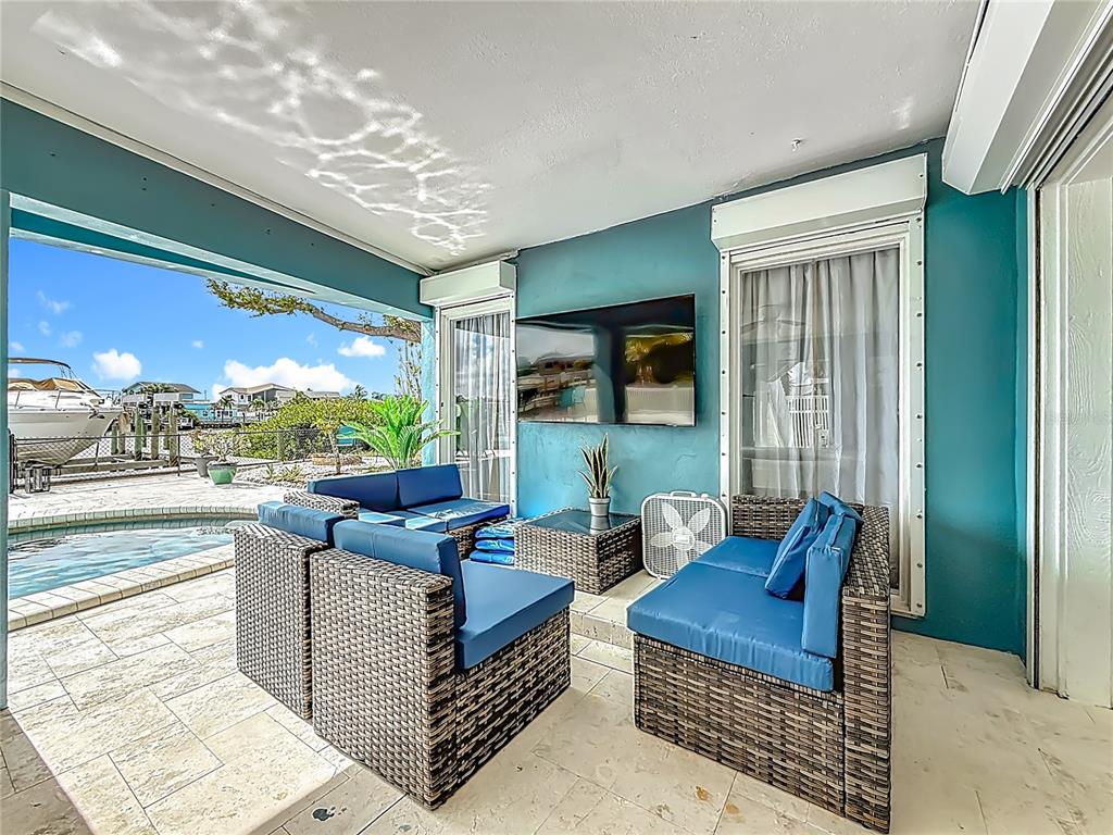 14186 West Parsley Drive Madeira Beach, FL 33708 - Photo 39 of 57 a outdoor living space with furniture and a flat screen tv