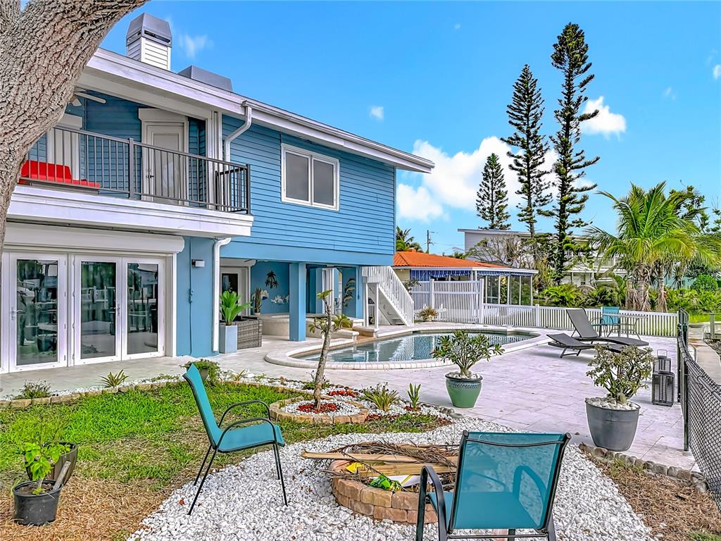 14186 West Parsley Drive Madeira Beach, FL 33708 - Photo 47 of 57 a view of a patio with table and chairs potted plants and palm tree