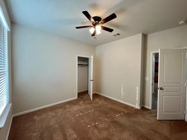 a view of an empty room with a ceiling fan