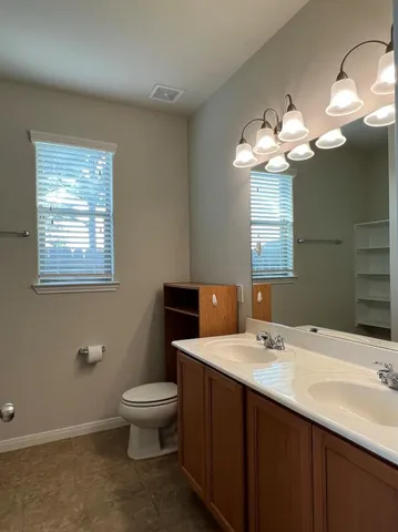 a bathroom with a sink a toilet and a mirror