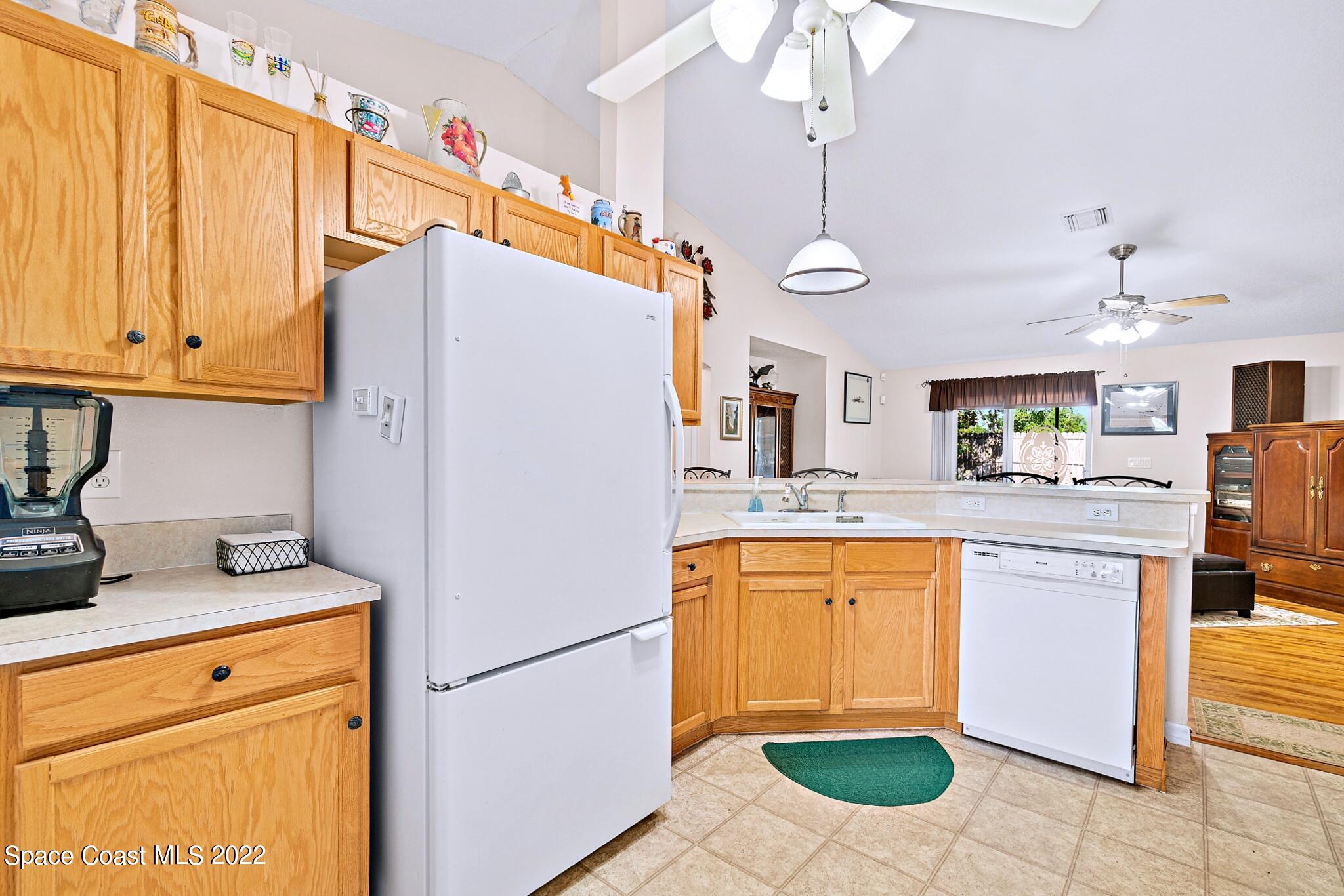5449 Flint Road Cocoa, FL 32927 - Photo 16 of 36 a kitchen with stainless steel appliances granite countertop a refrigerator a sink dishwasher and white cabinets with wooden floor