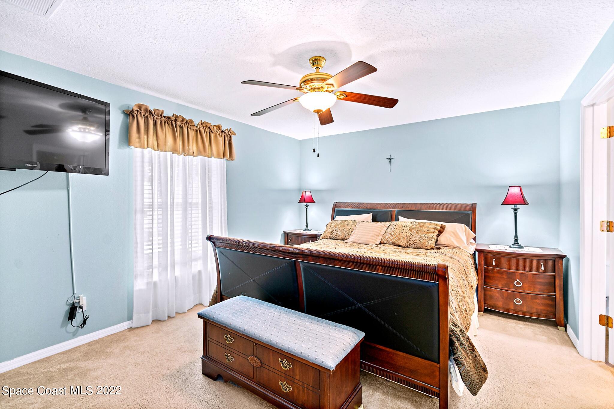 5449 Flint Road Cocoa, FL 32927 - Photo 18 of 36 a bedroom with a bed and a chandelier