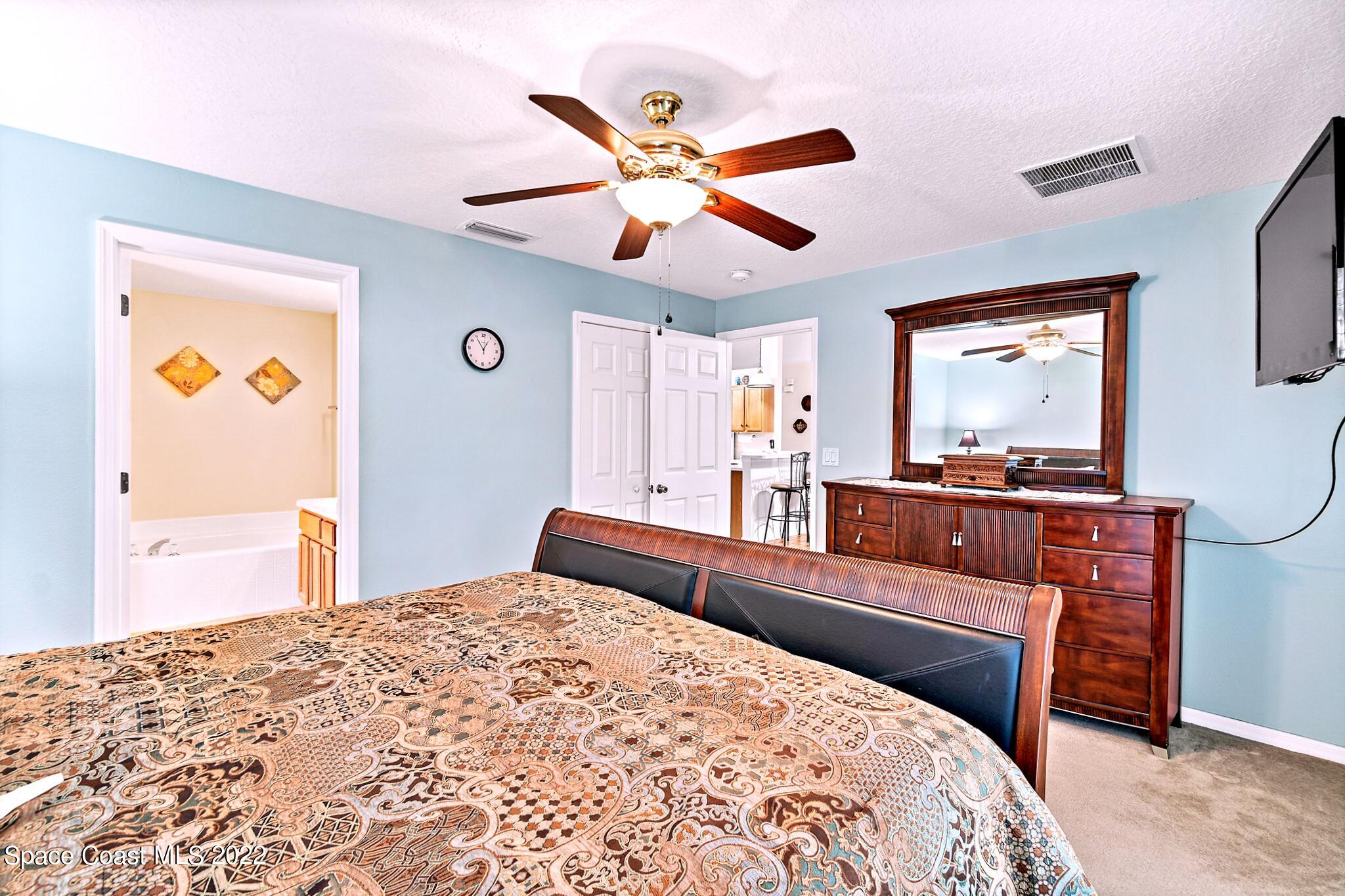 5449 Flint Road Cocoa, FL 32927 - Photo 19 of 36 a bedroom with a bed and dresser with mirror