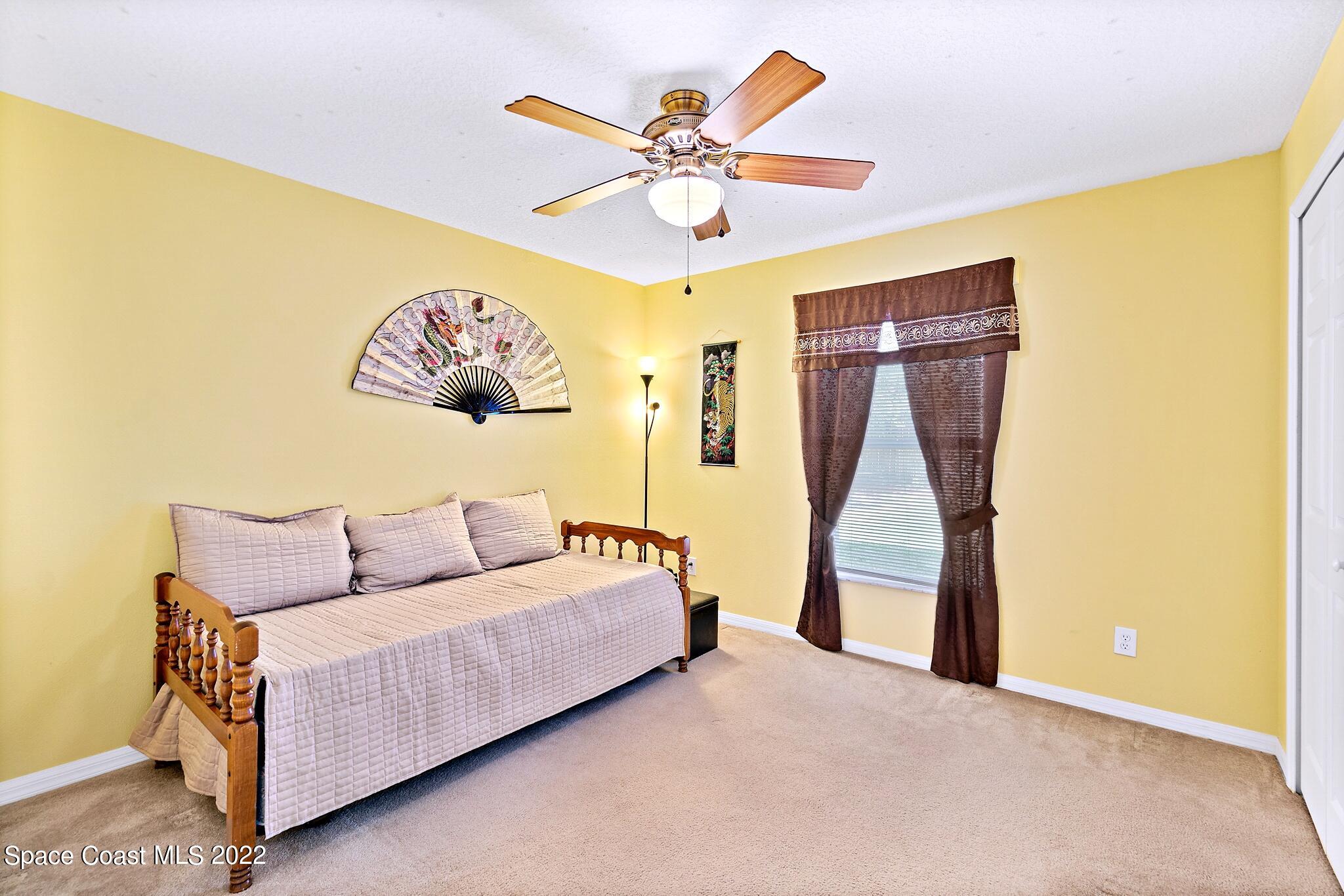 5449 Flint Road Cocoa, FL 32927 - Photo 23 of 36 a living room with a couch and a ceiling fan