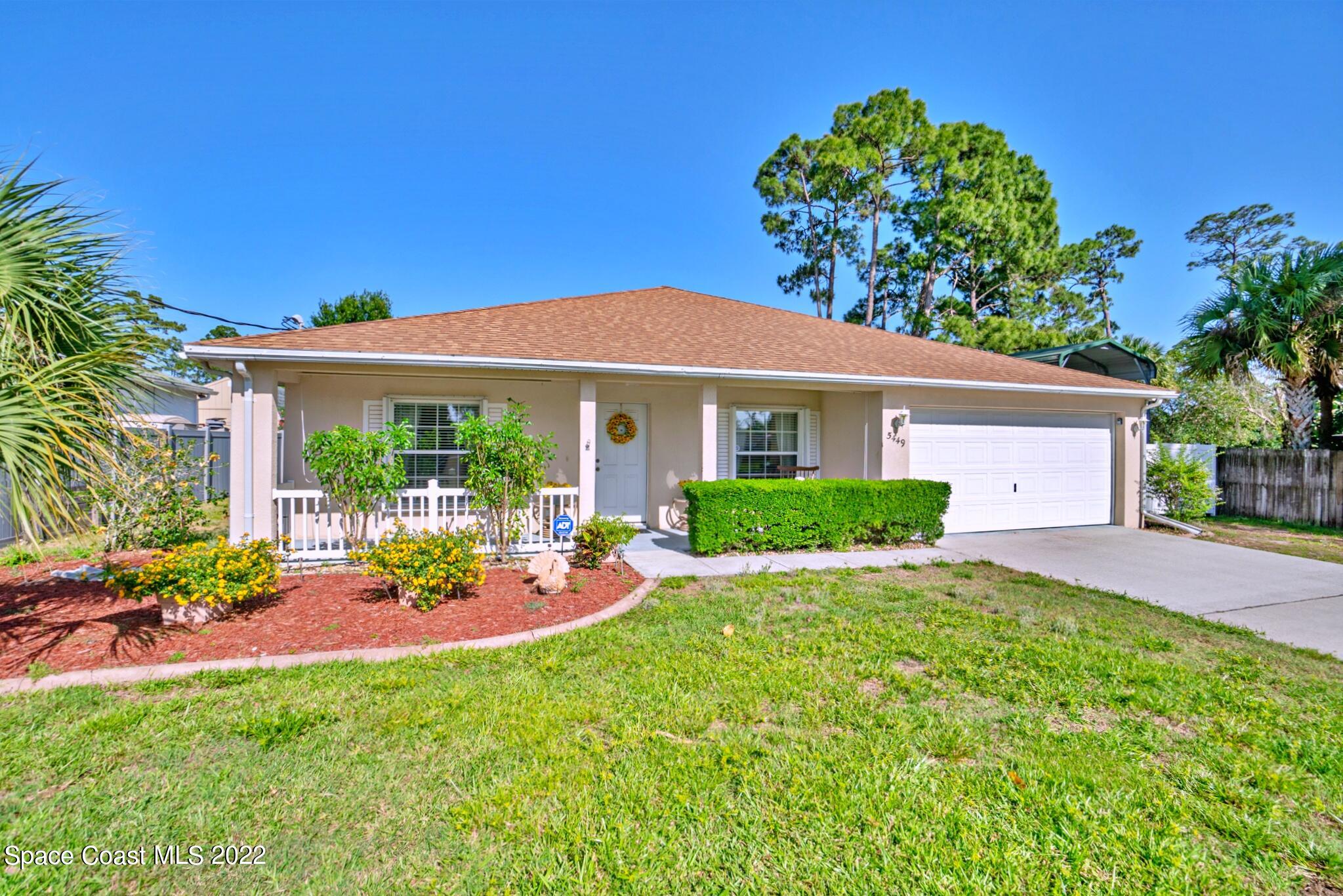 5449 Flint Road Cocoa, FL 32927 - Photo 3 of 36 a front view of a house with a yard and porch