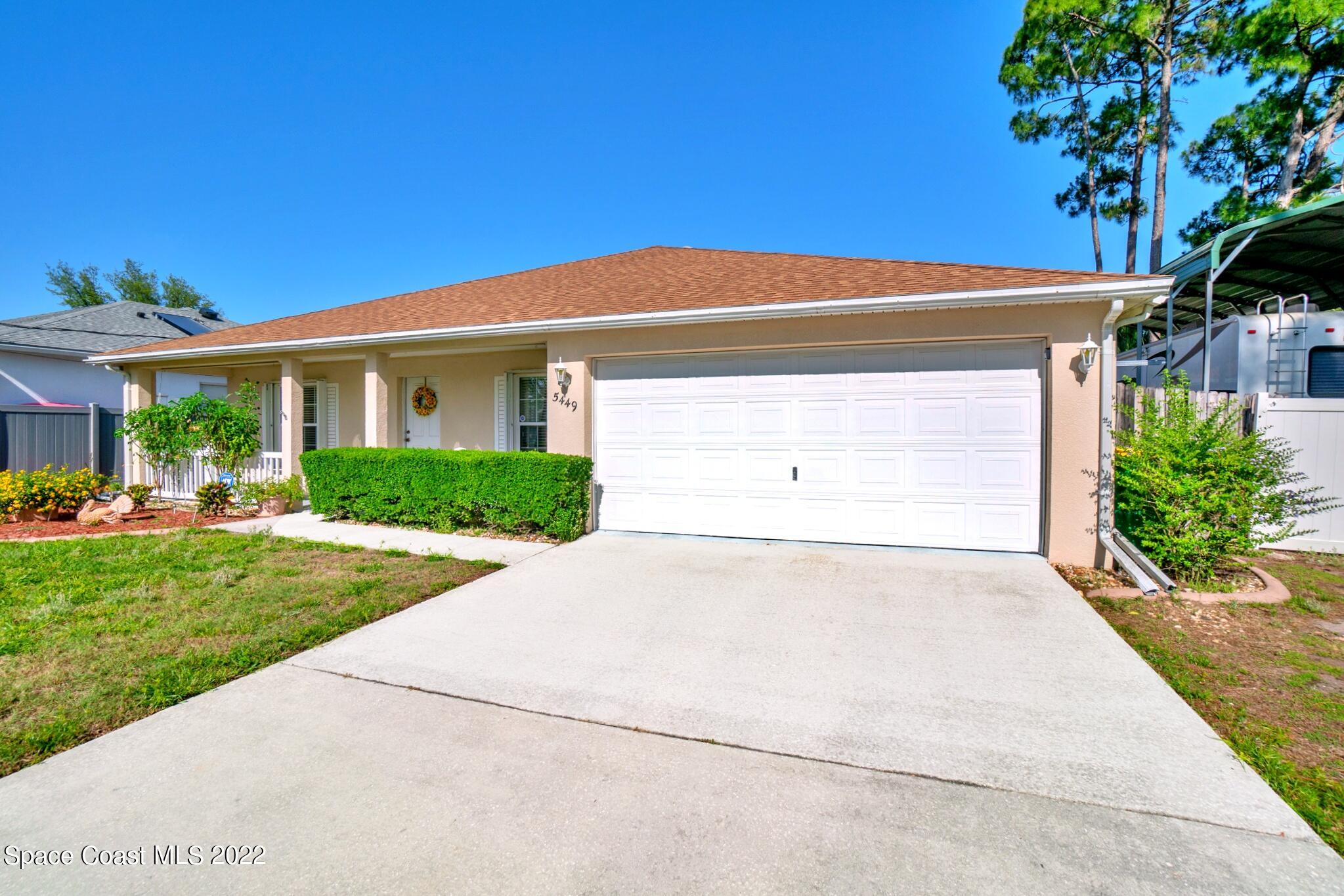 5449 Flint Road Cocoa, FL 32927 - Photo 5 of 36 a front view of a house with a yard and garage