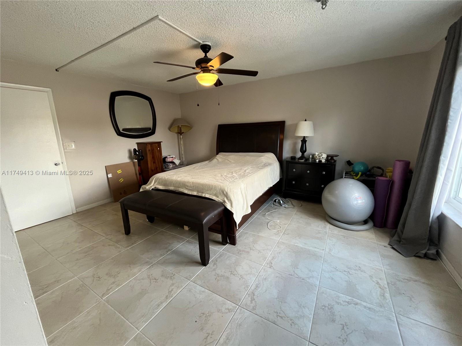 3924 Southwest 67th Terrace, Unit 117 Davie, FL 33314 - Photo 13 of 18 a bedroom with a bed and lamp