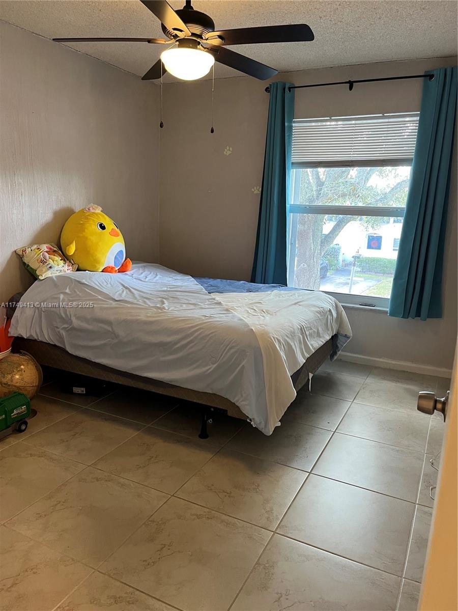 3924 Southwest 67th Terrace, Unit 117 Davie, FL 33314 - Photo 16 of 18 a bedroom with a bed and window