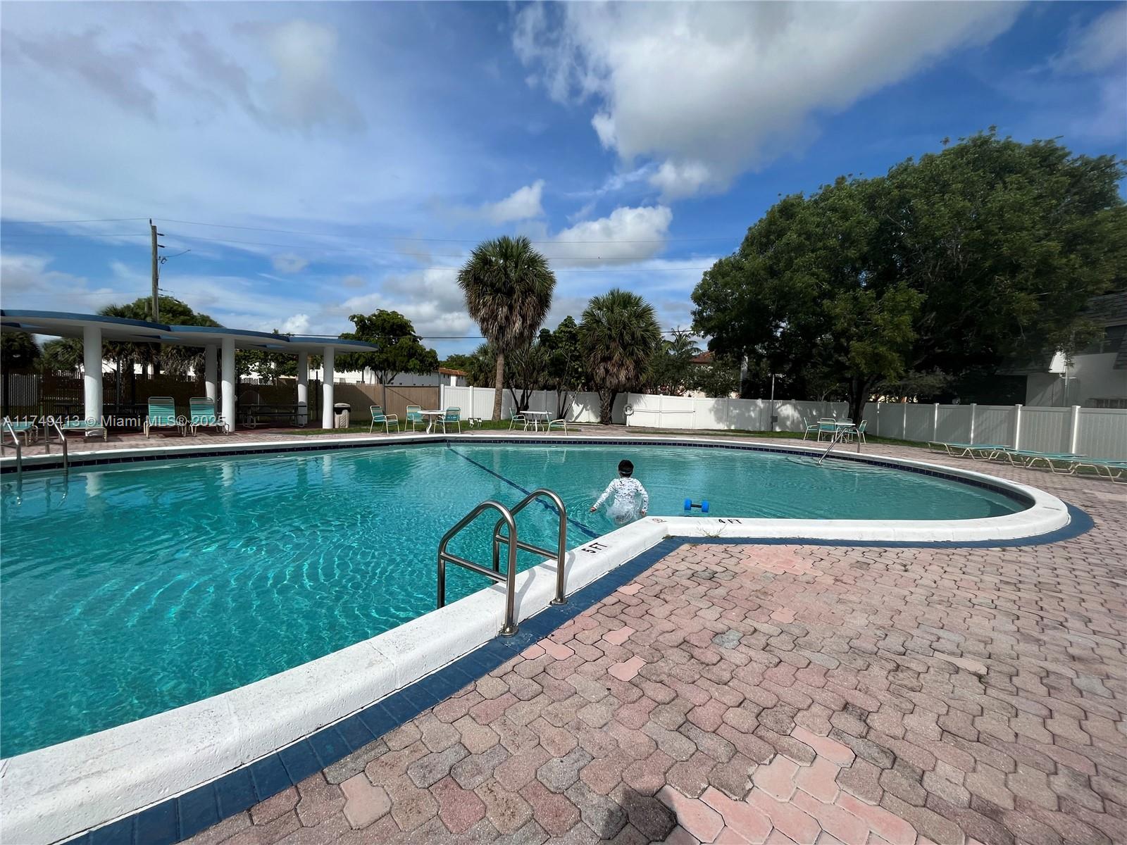 3924 Southwest 67th Terrace, Unit 117 Davie, FL 33314 - Photo 17 of 18 a view of a swimming pool with a yard