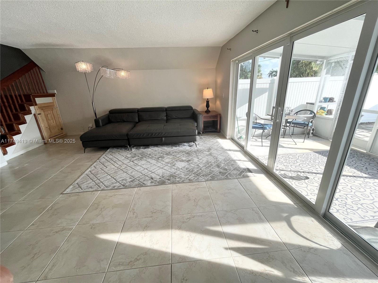 3924 Southwest 67th Terrace, Unit 117 Davie, FL 33314 - Photo 4 of 18 a living room with furniture and a floor to ceiling window