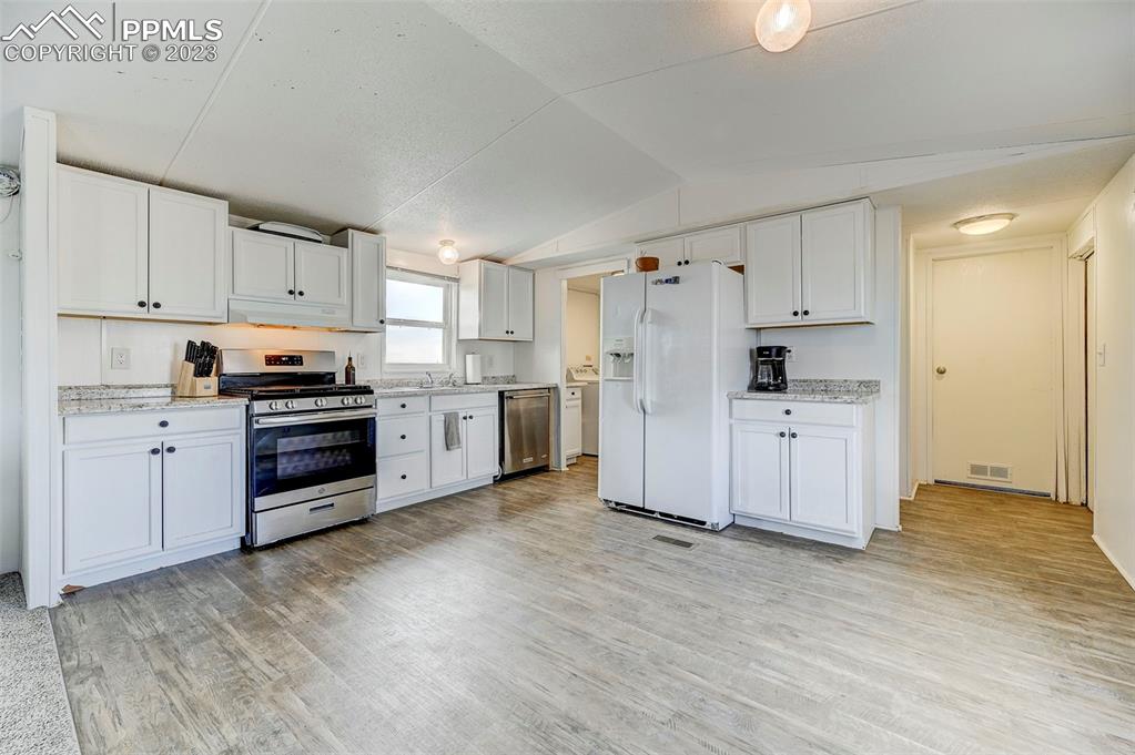 35525 Fossinger Road Yoder, CO 80864 - Photo 13 of 38 a kitchen with white cabinets and white appliances