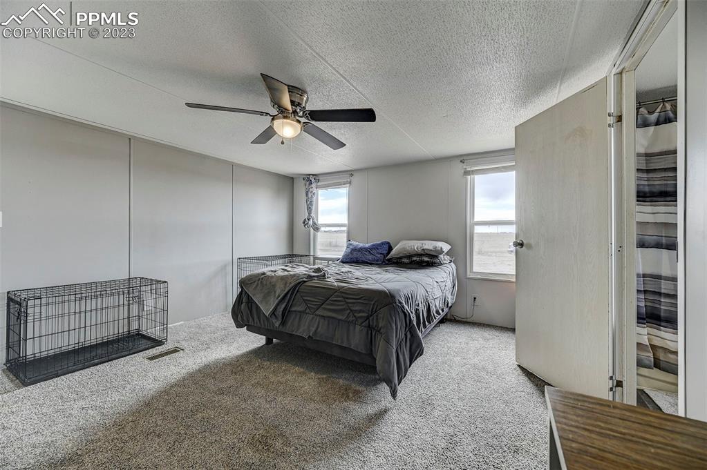 35525 Fossinger Road Yoder, CO 80864 - Photo 16 of 38 a bedroom with a bed and a chandelier
