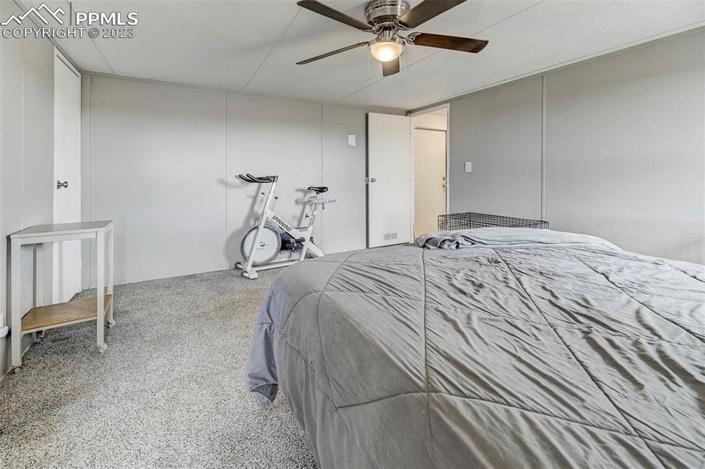 35525 Fossinger Road Yoder, CO 80864 - Photo 19 of 38 a bedroom with a bed and a chandelier