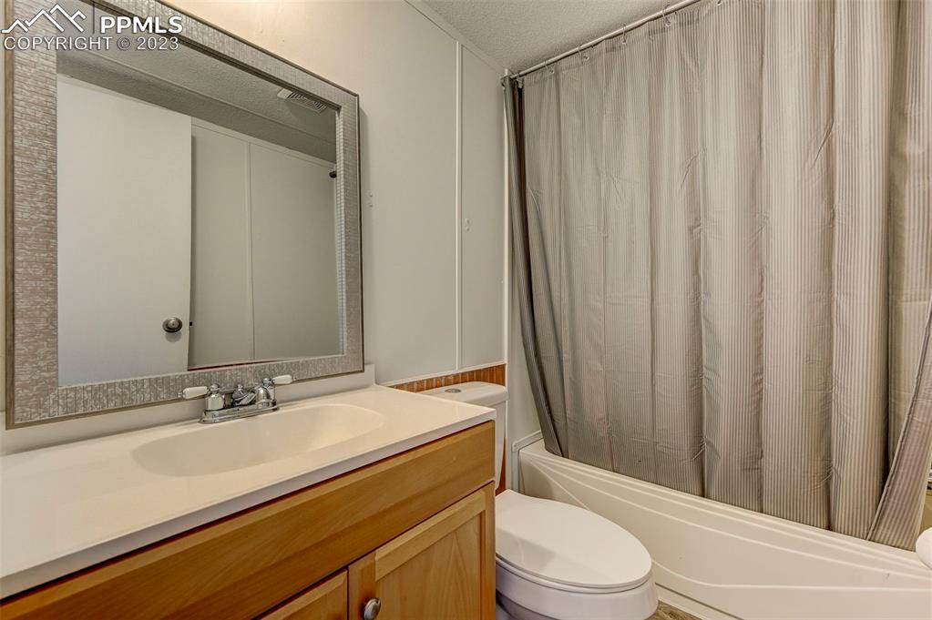 35525 Fossinger Road Yoder, CO 80864 - Photo 23 of 38 a bathroom with a sink a toilet a mirror and shower curtain