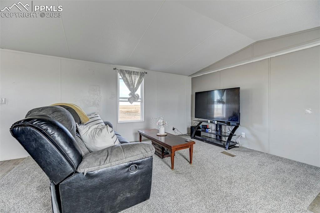 35525 Fossinger Road Yoder, CO 80864 - Photo 9 of 38 a living room with furniture and a flat screen tv