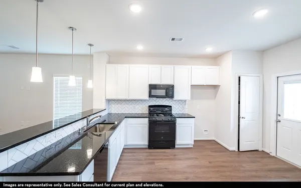 a kitchen with stainless steel appliances granite countertop a sink a stove and a refrigerator