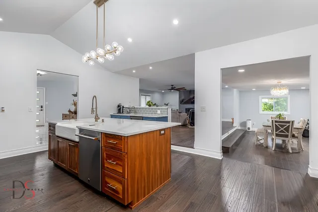 a kitchen with stainless steel appliances granite countertop a kitchen island a stove a table and chairs