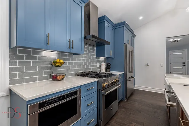 a kitchen that has a lot of cabinets in it and wooden floors