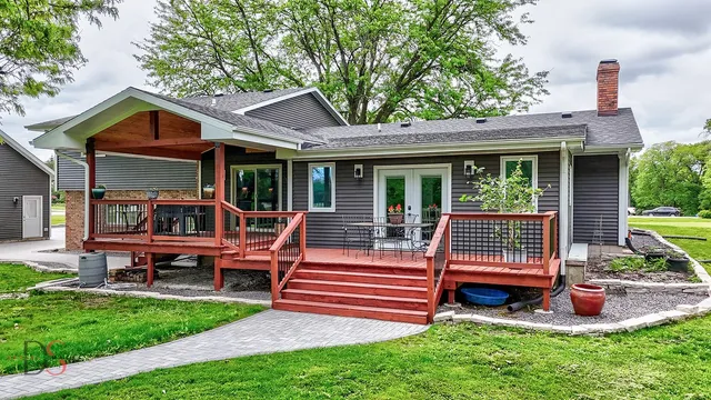 a view of backyard with deck and garden